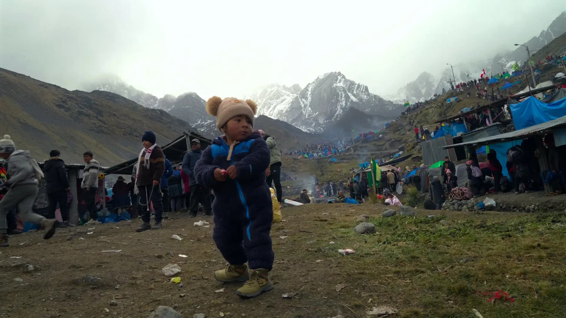 A child at a sacred Andean gathering below snow-capped peaks, from The Sacred Ascent
